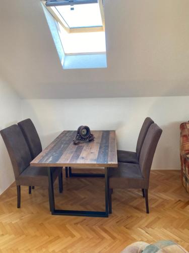 a dining room table with two chairs and a skylight at Family apartment Tara in Mojkovac