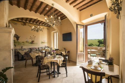 a restaurant with tables and chairs and a large window at Palazzo Pacini in Colle Val D'Elsa