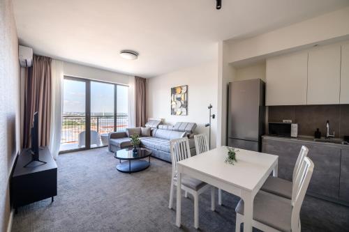 a living room with a white table and a kitchen at Belgrade Waterfront Residences - Beograd na vodi in Belgrade