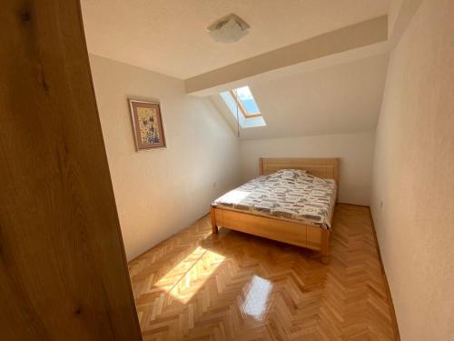 a small bedroom with a bed and a window at Family apartment Tara in Mojkovac