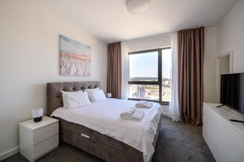 a bedroom with a large bed and a television at Belgrade Waterfront Residences - Beograd na vodi in Belgrade