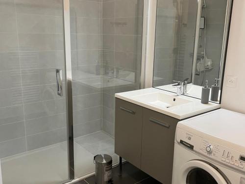 a bathroom with a shower and a sink and a washing machine at Appartement Samoëns, 2 pièces, 4 personnes - FR-1-629-128 in Samoëns