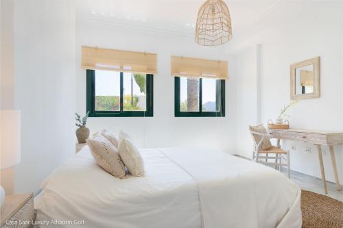 een witte slaapkamer met een bed en ramen bij Casa Saar Luxury Alhaurin Golf in Alhaurín el Grande