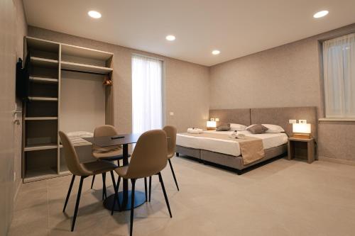 a bedroom with a bed and a table and chairs at Palazzo Borgo Trento - Royal Welcome in Verona