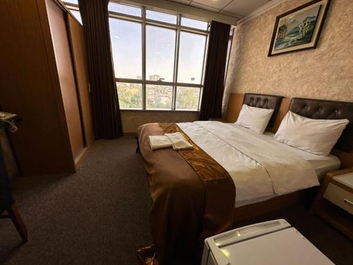 a hotel room with a bed and a window at Altin Saray Hotel Erbil in Erbil