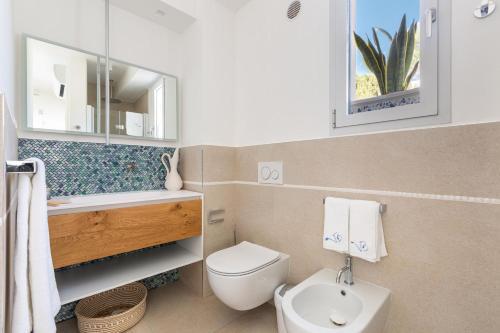y baño con aseo, lavabo y espejo. en Villa Briosa Maldive del Salento Pescoluse, en Torre Pali