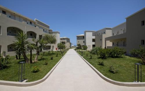 a walkway between two apartment buildings at Vantaris Luxury Beach Resort in Georgioupolis