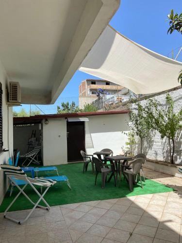a patio with tables and chairs on a green lawn at Villa Franca in Reggio Calabria