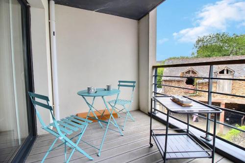 a balcony with a table and chairs and a window at L'Universel in Vannes