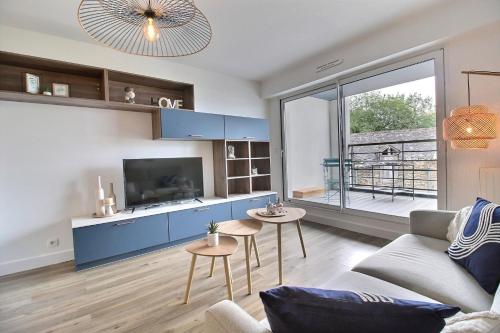 a living room with a couch and a tv at L'Universel in Vannes