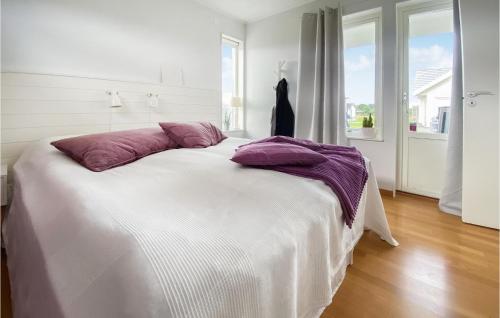 - un lit blanc avec des oreillers violets dans une chambre dans l'établissement Amazing Home In Falkenberg With Kitchen, à Falkenberg