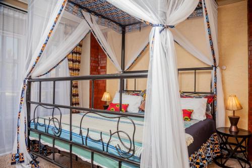 um quarto com uma cama de dossel com cortinas em Jet Villas Entebbe ( JVE ) em Entebbe