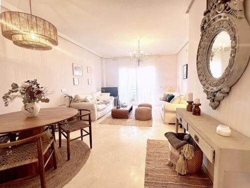 uma sala de estar com uma mesa e um espelho em Los Jardines Del Mar em Manilva