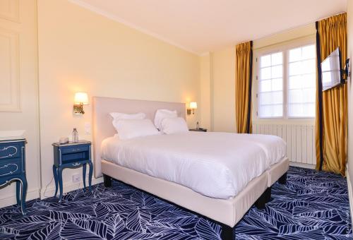 Un dormitorio con una gran cama blanca y una ventana en Hostellerie Saint Pierre, en Saint-Pierre-du-Vauvray