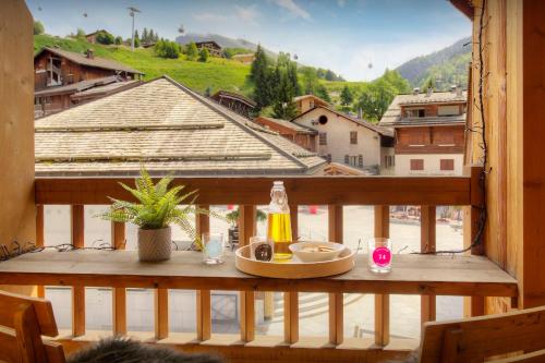 a table with a plate of food on a balcony at Chalet Artedaz - OVO Network in La Clusaz