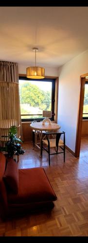 ein Wohnzimmer mit einem Tisch und einem Fenster in der Unterkunft Studio Matosinhos Sul in Matosinhos
