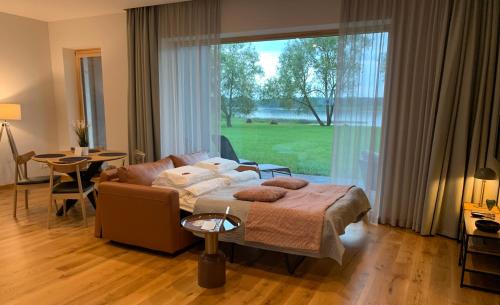 uma sala de estar com um sofá e uma grande janela em Idille1 em Ikšķile