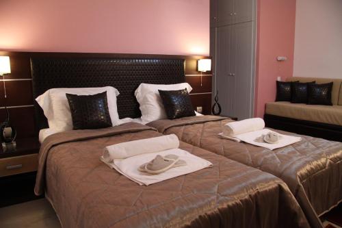 a hotel room with two beds with towels on them at Lasia Hotel in Mytilene