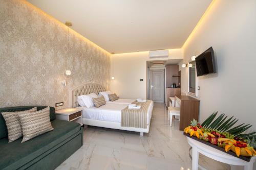 a bedroom with a bed and a living room with a couch at Vantaris Luxury Beach Resort in Georgioupolis