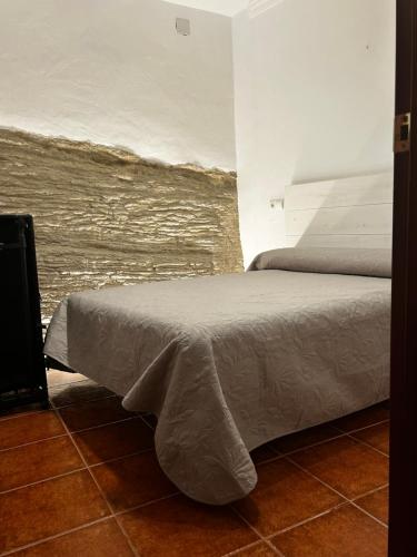Un dormitorio con una cama con una manta. en Apartamento ¨El lizón¨, en Setenil
