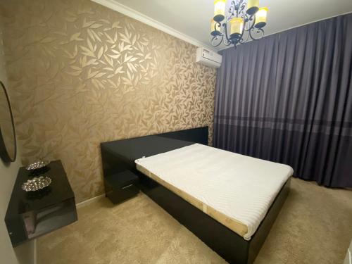 Dormitorio pequeño con cama y mesa en Уютная квартира, en Tashkent