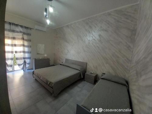 sypialnia z 2 łóżkami w pokoju ze ścianą w obiekcie casa Mondragone 50 metri dall'acqua w mieście Mondragone
