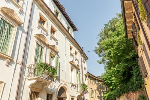 a row of buildings with balconies and a tree at Domus Verona - Residenza Merici in Verona