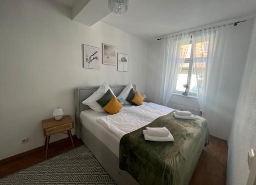ein Schlafzimmer mit einem Bett mit gelben Kissen und einem Fenster in der Unterkunft NEST - hell und gemütlich im Herzen Fuldas in Fulda
