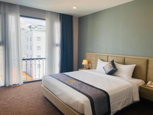a bedroom with a large bed and a large window at Hera Luxury Hotel in Ho Chi Minh City