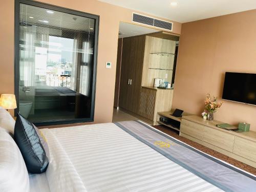 a bedroom with a large bed and a television at Hera Luxury Hotel in Ho Chi Minh City