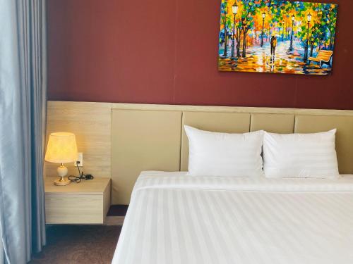 a bedroom with a bed and a painting on the wall at Hera Luxury Hotel in Ho Chi Minh City