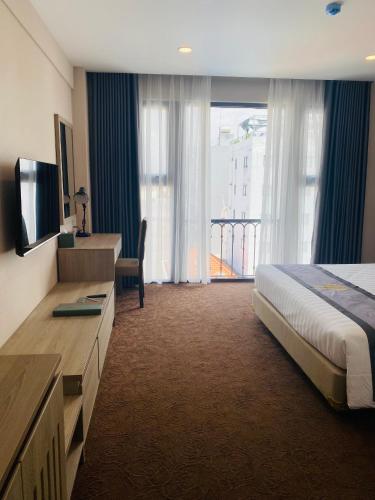 a hotel room with a bed and a large window at Hera Luxury Hotel in Ho Chi Minh City