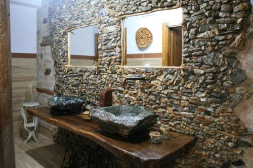 ein Steinbad mit einem Waschbecken und einem Spiegel in der Unterkunft Il Podere dell'Angelo Old Country House in Belvedere Marittimo