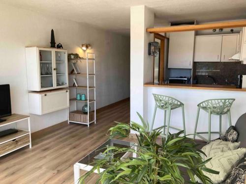 uma sala de estar com uma cozinha e uma sala de estar com um sofá em Apartament amb vistes al mar! em Salou