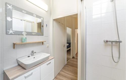 a white bathroom with a sink and a shower at Oesterbaai - 5personen in Wemeldinge