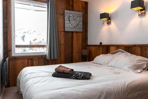 a bedroom with a bed with a towel on it at IMMODREAMS - Chalet Le Grand Paradis - Avoriaz in Avoriaz