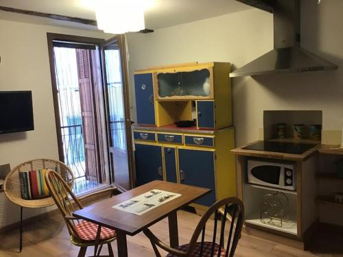 una pequeña cocina con mesa, mesa pequeña y sillas en Chez Jules, en Saint-Martin-Vésubie