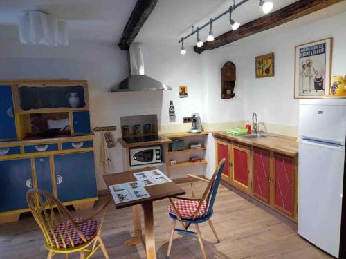 cocina con armarios coloridos, mesa y sillas en Chez Jules, en Saint-Martin-Vésubie
