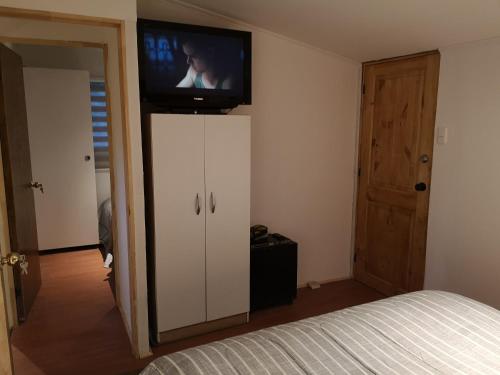 a bedroom with a television on top of a cabinet at CABAÑA LIRCAY - 2 habitaciones 48M2 para 4 personas in San Clemente