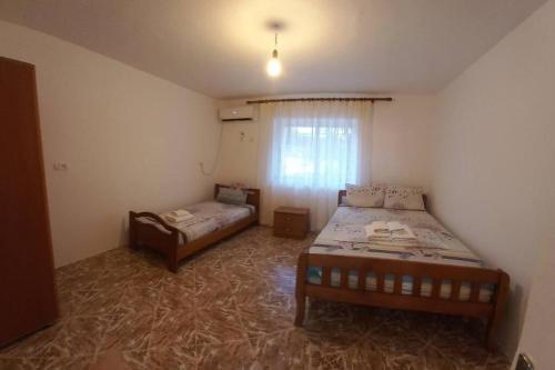 a bedroom with two beds and a window in it at Λευκό σπίτι in Ksamil