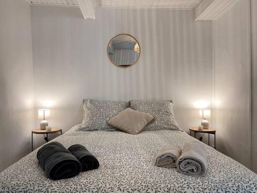 ein Schlafzimmer mit einem Bett mit zwei Kissen und einem Spiegel in der Unterkunft Maison Opaline in Berck-sur-Mer