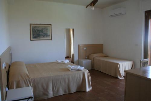 a hotel room with two beds and a table at Il Podere dell'Angelo Old Country House in Belvedere Marittimo