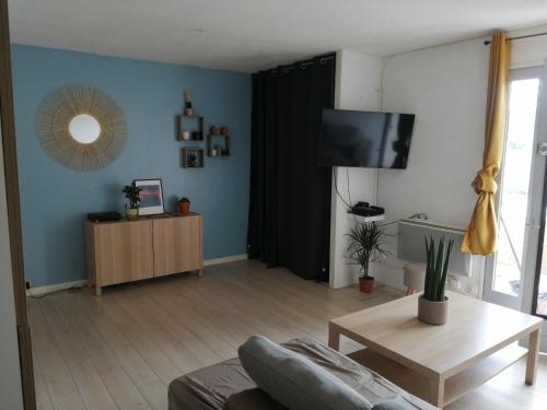 sala de estar con sofá y TV en Appartement au pied des dunes, en Seignosse