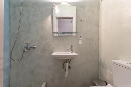 a bathroom with a sink and a mirror at Casa Estiva Apeiranthos Naxos Apartments in Naxos Chora
