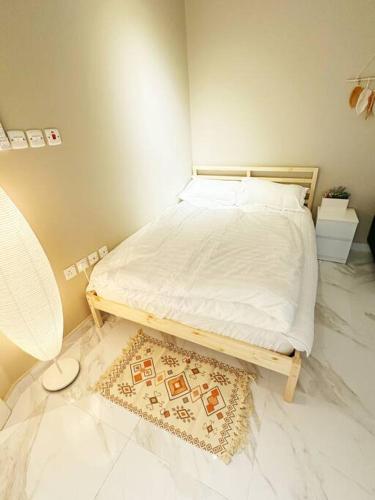 een slaapkamer met een bed en een tapijt op de vloer bij Elegant and luxurious one bedroom studio, side entrance 1D in Riyad
