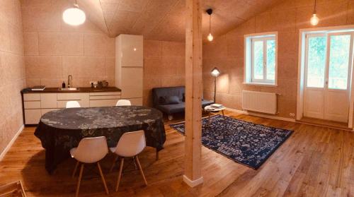 a room with a table and chairs and a kitchen at Pērlerada room in Engure