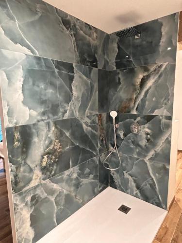 La salle de bains est pourvue d'un mur en marbre. dans l'établissement Villa Catalya moderne piscine chauffée, à Carcassonne