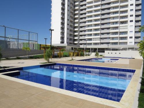 Recanto do Bosque Apartamentos para Temporada في كالدس نوفاس: مسبح امام مبنى كبير
