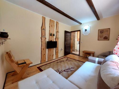 a living room with a white couch and wooden floors at Šumska bajka in Bajina Bašta