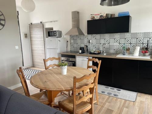 une cuisine et une salle à manger avec une table et des chaises dans l'établissement La maison sur la plage, à Marennes